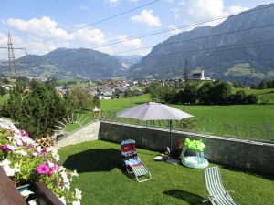 Blick auf die malerische Landschaft von St. Veit im Pongau mit Liegewiese und Gartenmöbeln.