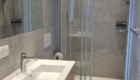 Moderne Badezimmerausstattung mit Dusche, Waschtisch und neutralem Farbton im Haus Sonnenterrasse.