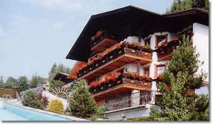 Appartementhaus mit Balkonen und Blumen in St. Veit im Pongau, umgeben von Natur.
